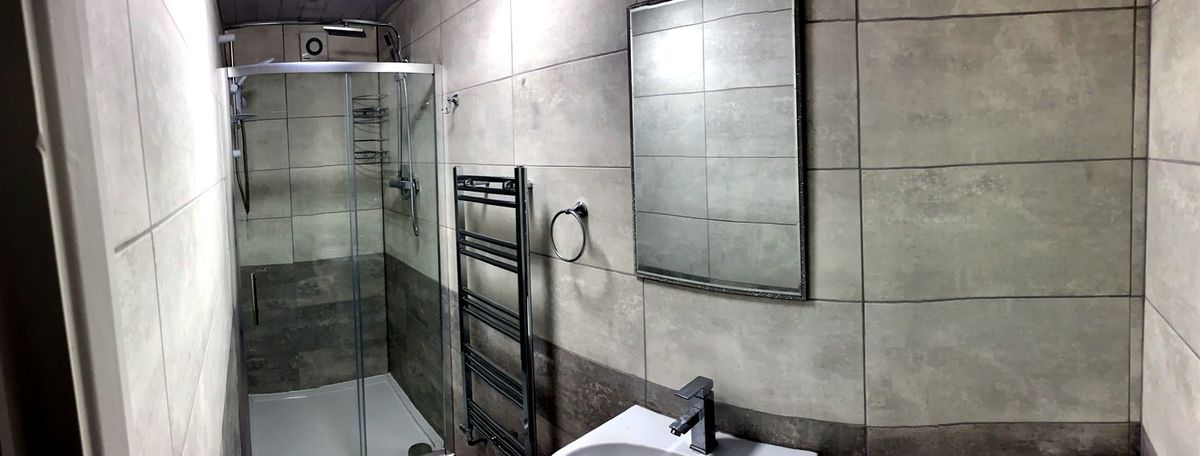 Shower room renovation with grey tiling and walk-in enclosure