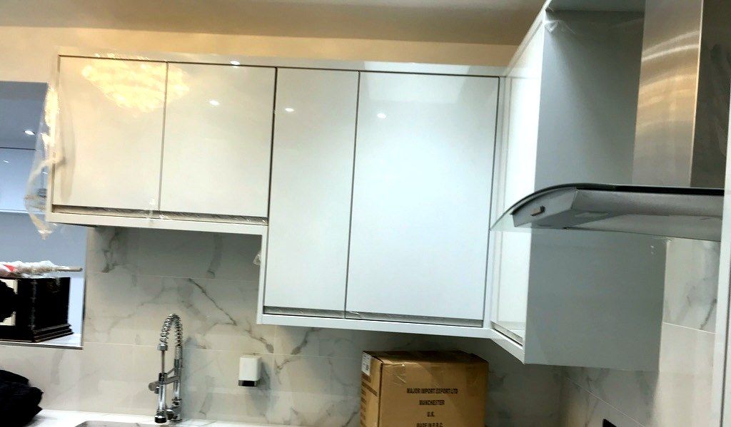 High-gloss white kitchen fit-out with marble-effect splashback